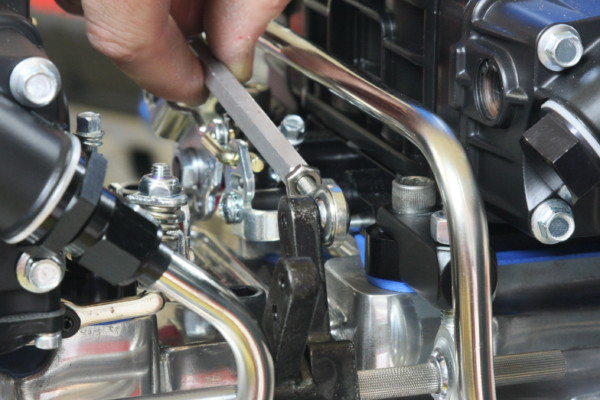 man installing heim joint on carb linkage