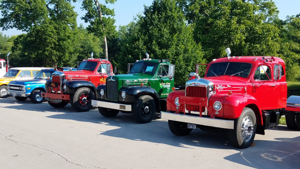 row of old classic vintage trucks at car show