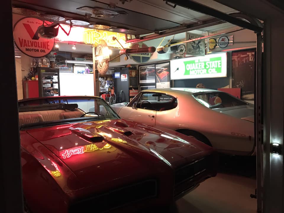 a pair of second gen pontiac gtos parked in a garage
