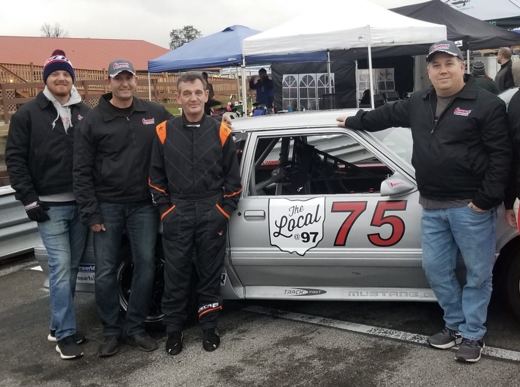 bmr race team standing next to fox body mustang race car