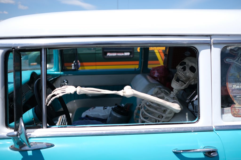 skeleton in the driver's seat of a classic car
