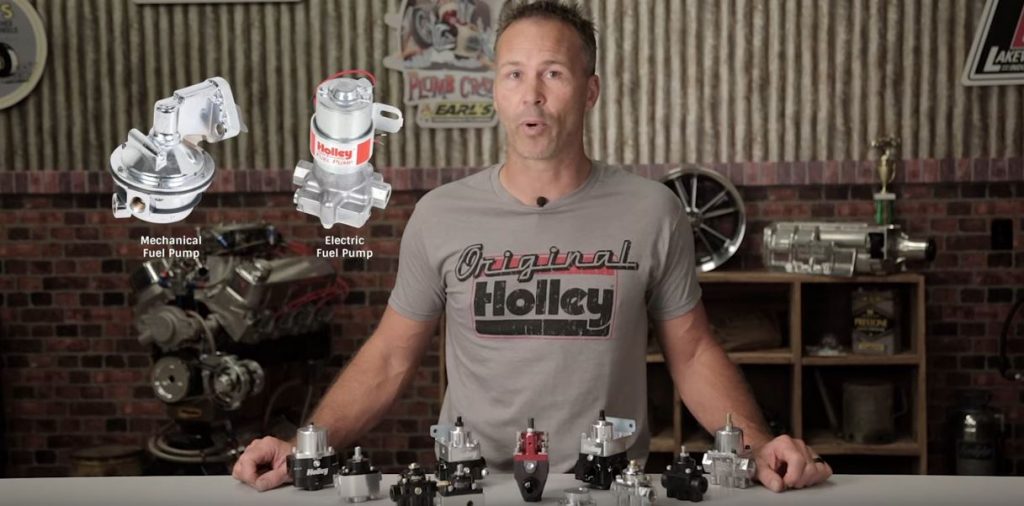 man standing in front of fuel pressure regulators