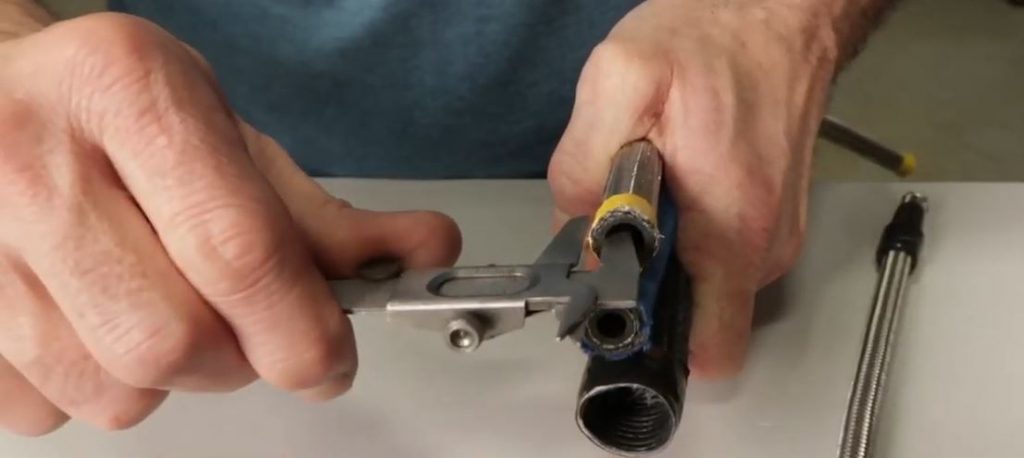 man using measuring calipers to check size of custom an hose fitting