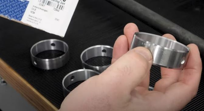 man holding a camshaft engine bearing