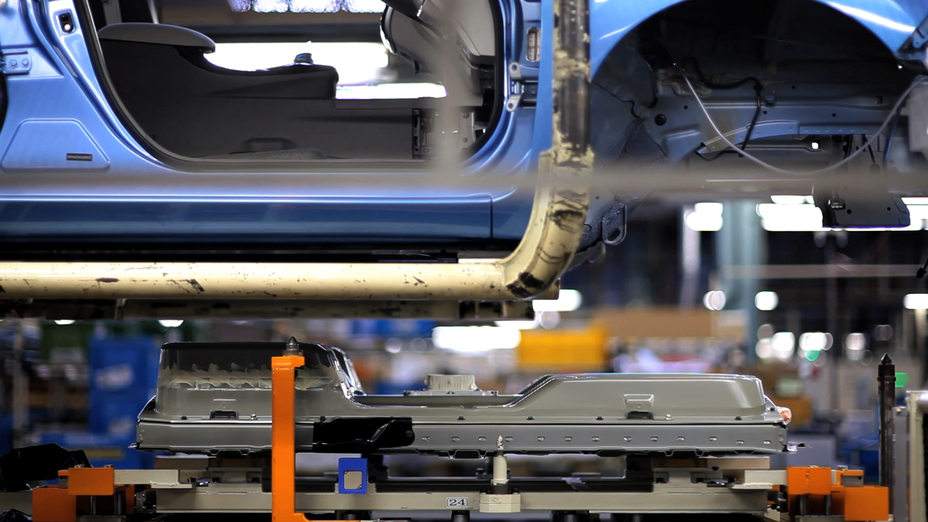 an electric vehicle battery being installed at a nissan leaf factory