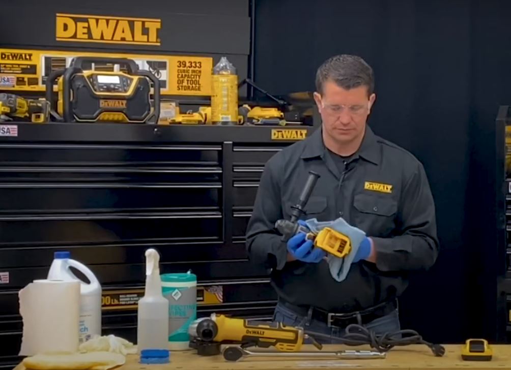 man at workbench cleaning dewalt tools