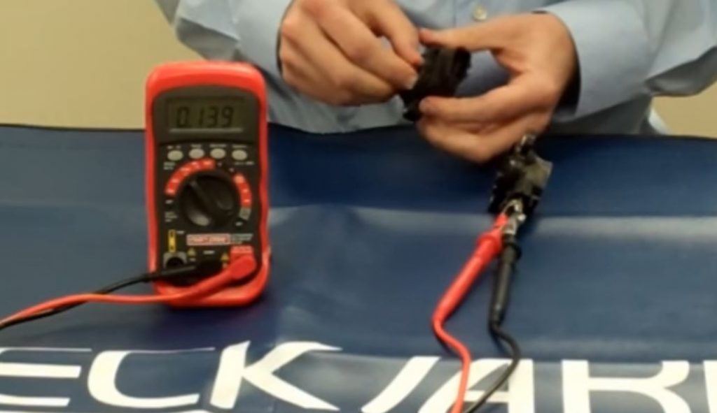 a man troubleshooting a throttle position sensor with a digital multimeter