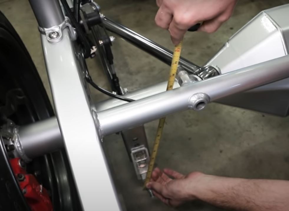 man using tape measure to calculate shock absorber and coilover length
