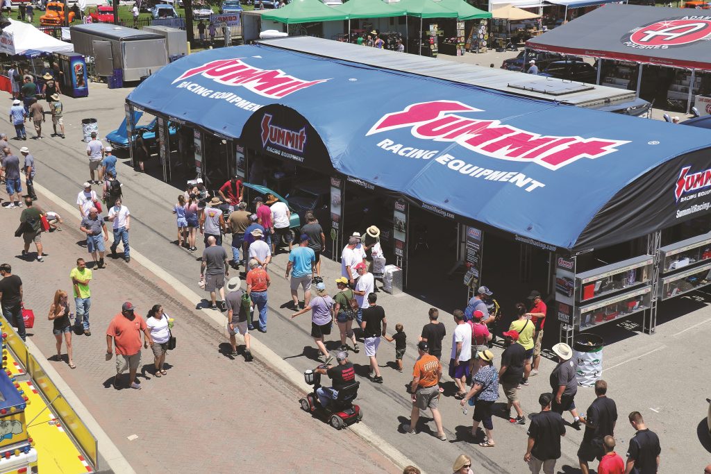 summit racing event tent with crowd at large car show