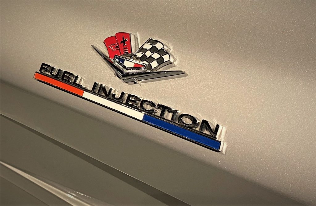 close up of fuel injection fender badge on 1963 chevy corvette sting ray silver