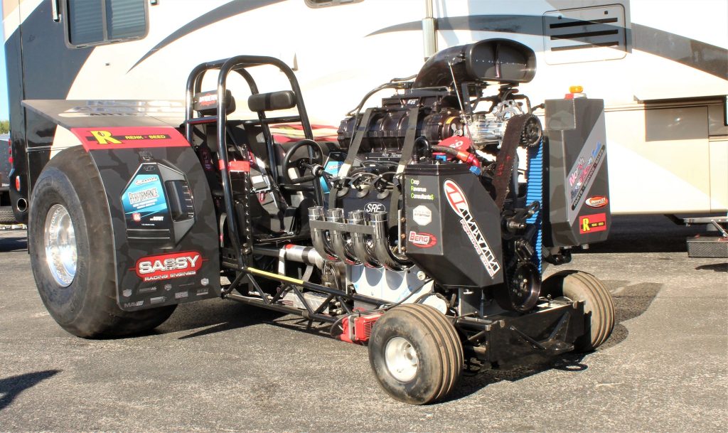 professional tractor pulling race tractor at a race next to a camper