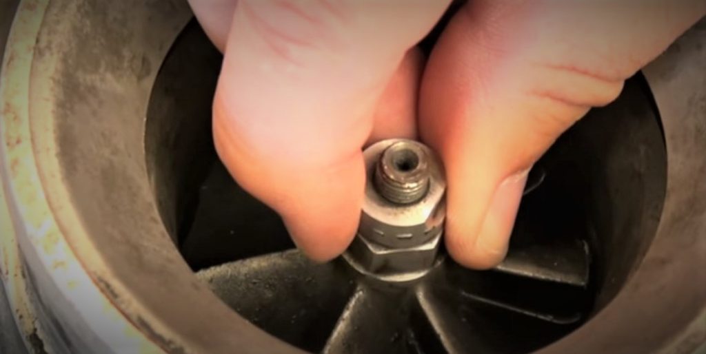 man installing turbine impeller blade in a turbocharger