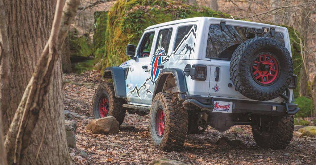 rear shot of summit racing project jeep wrangler unlimited rubicon heading down a trail