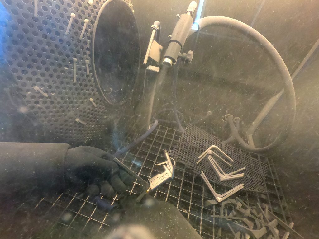 parts getting shot peened in a blasting cabinet