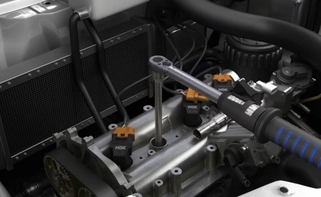 computer animation still of torque wrench on a spark plug