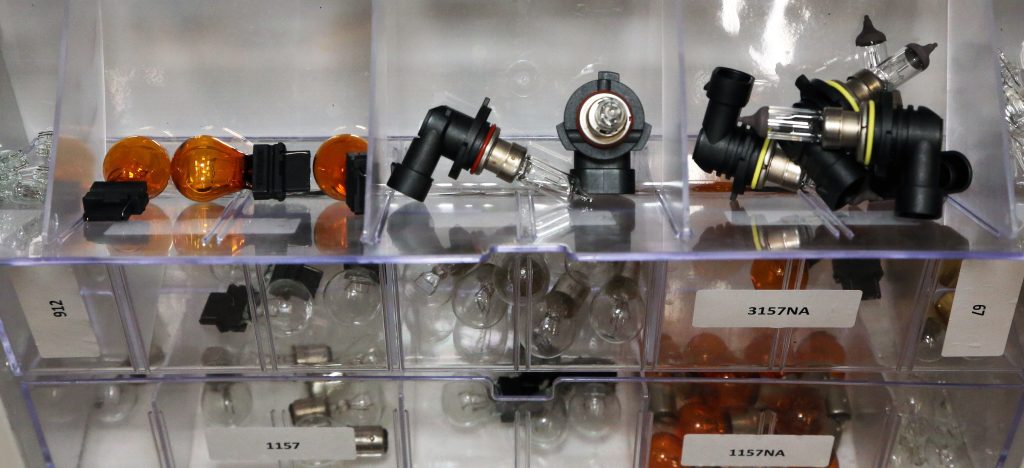 collection of headlights and bulbs in an organizer case