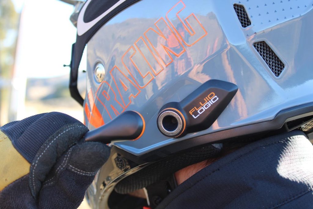 man connecting a fluidlogic race hydration system to his helmet