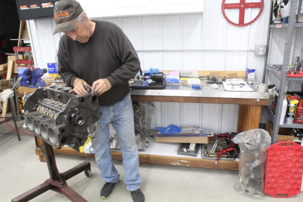 man using a feeler gauge on an engine block cylinder bore