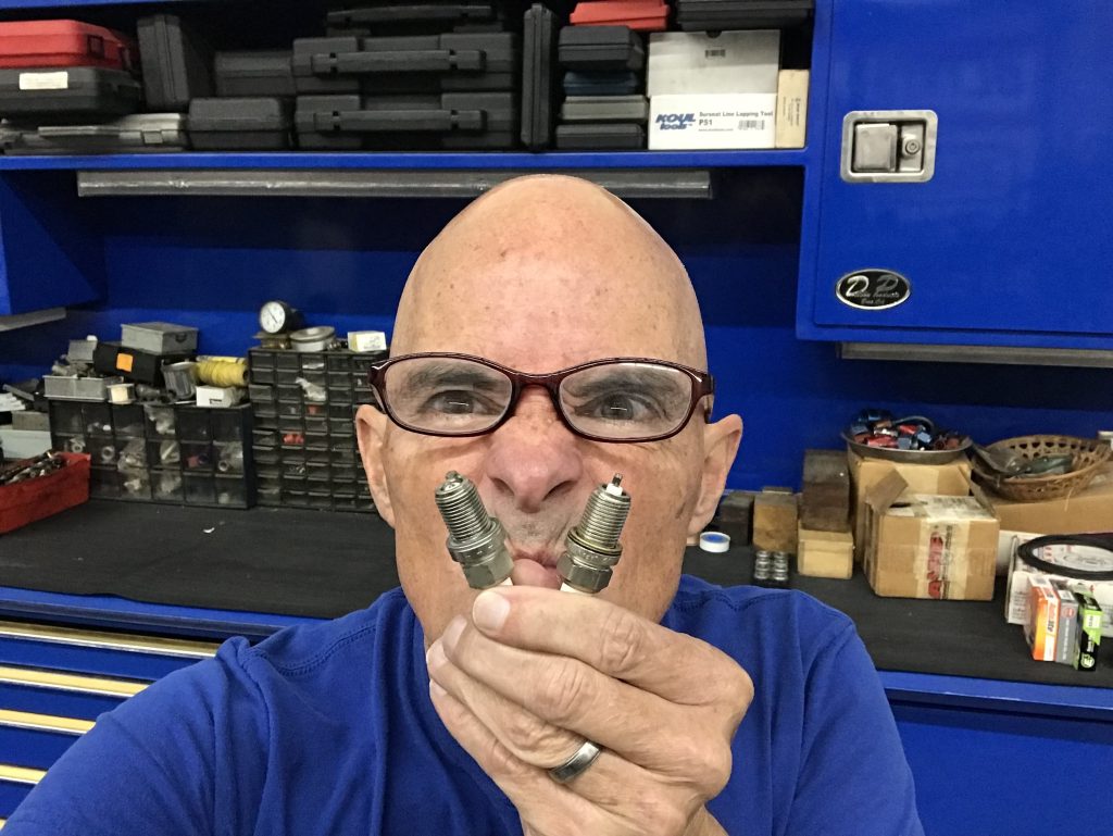 man holding a pair of spark plugs