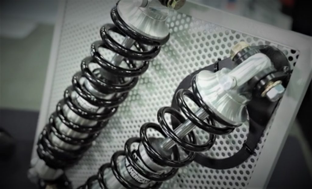 a pair of coilover suspension parts in a trade show display