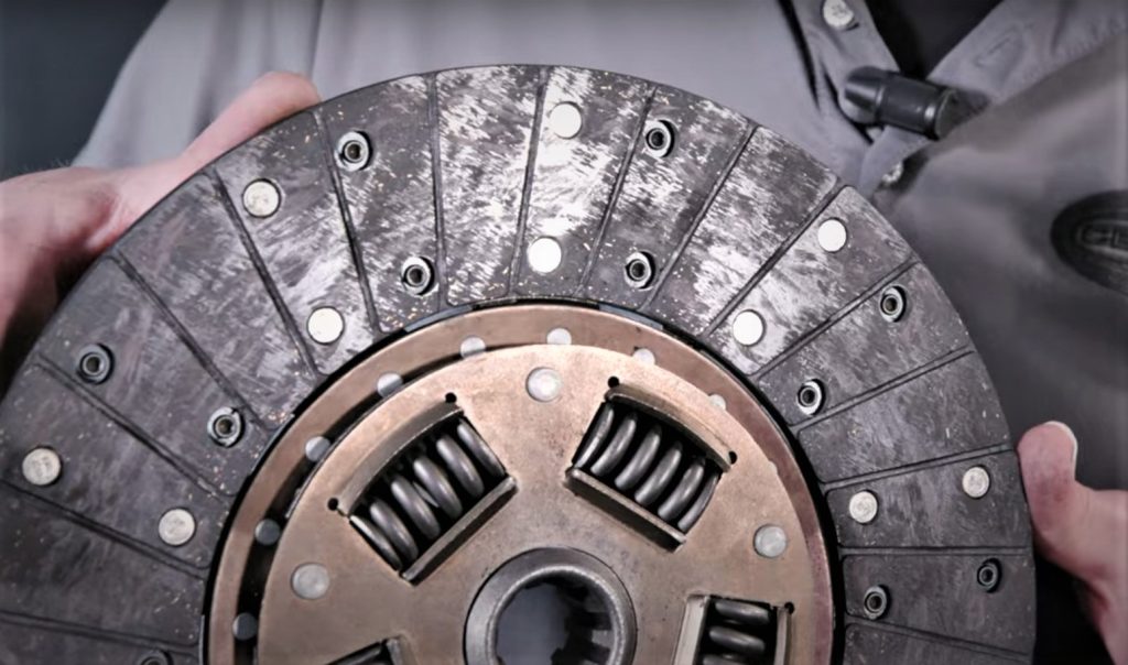 close up of a man holding a clutch disc