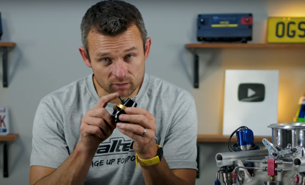 man holding a fuel pressure regulator