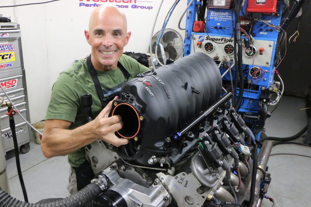 man holding an ls engine intake manifold