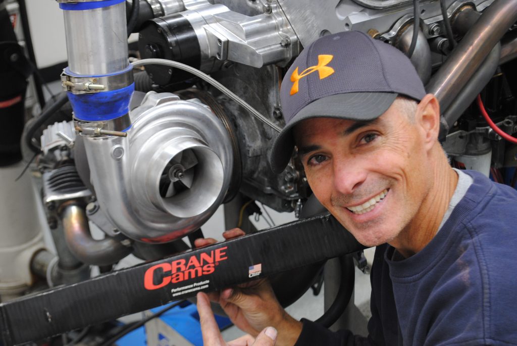 man holding camshaft box next to a turbo