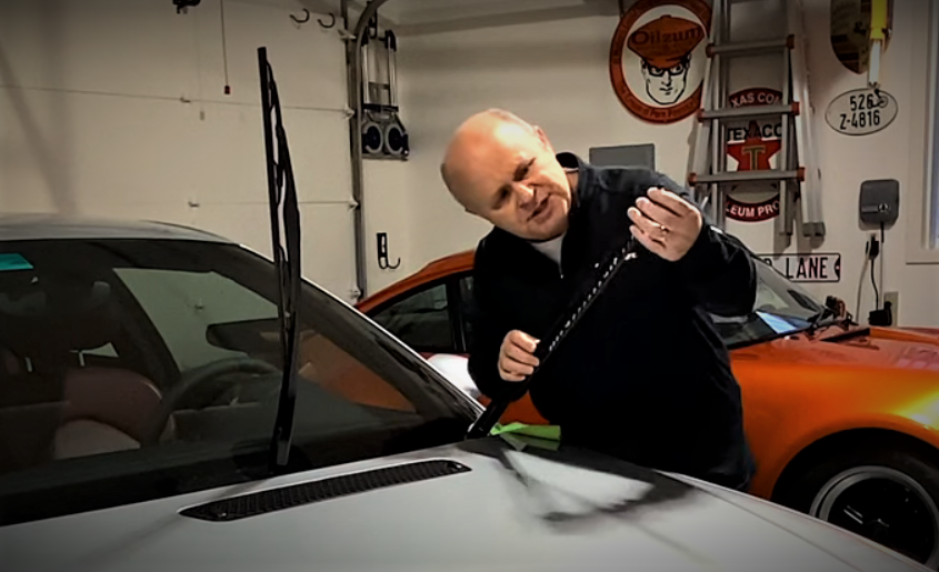 man inspecting windshield wiper blade
