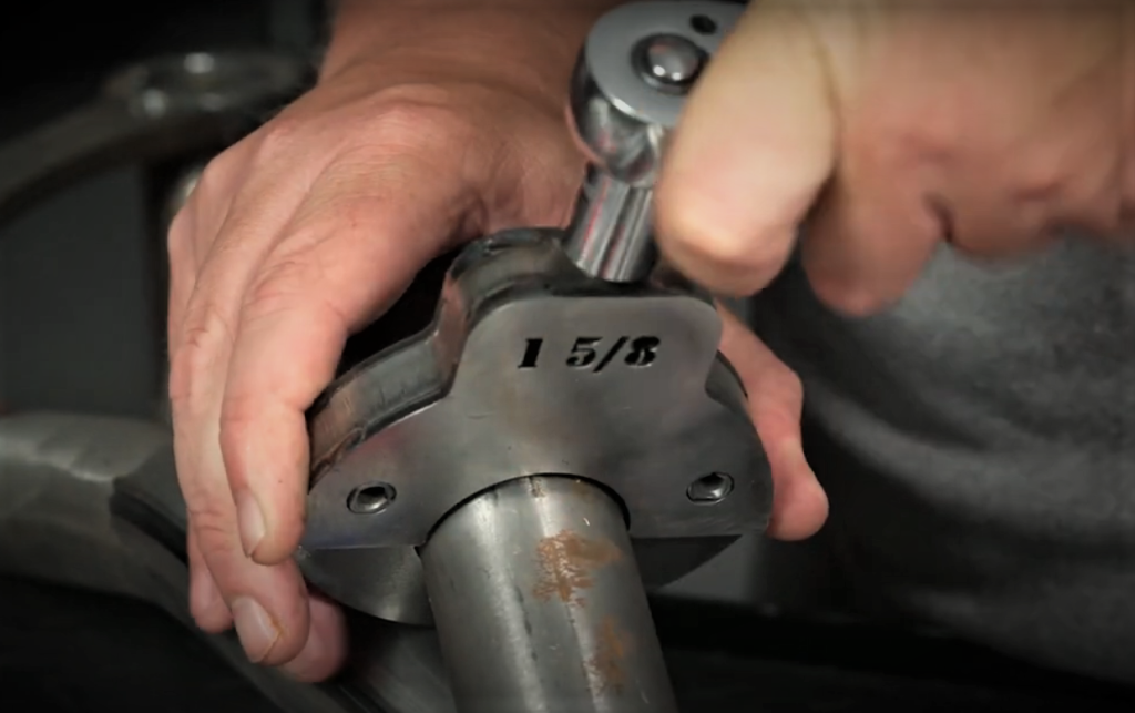 man dimpling a header tube using a specialty pipe shaper tool