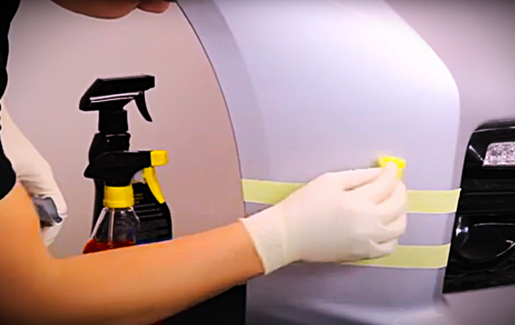 man prepping a surface for paint adhesion