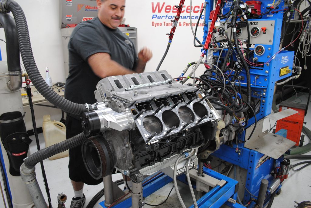 man installing an ls engine onto a dyno