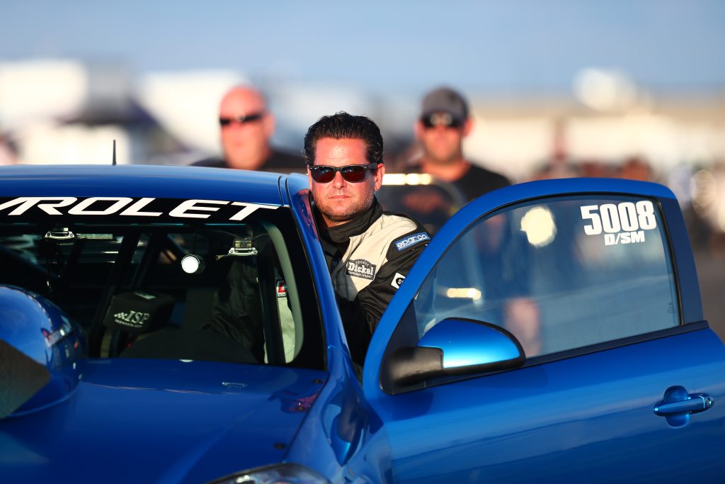 man getting into a drag race car