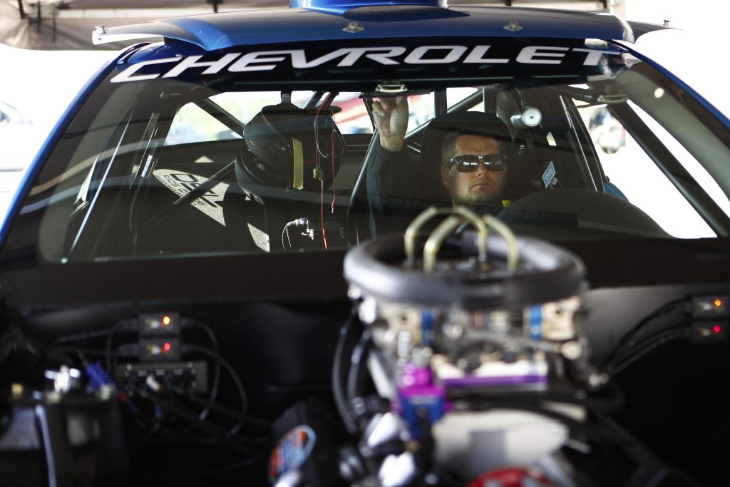 man in cockpit of drag race car