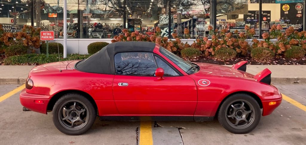 side profile shot of a red mazda miata NA