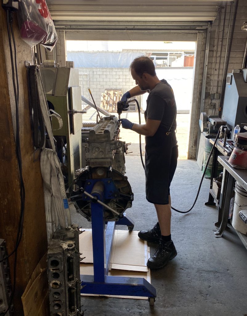 man removing parts from a truck engine