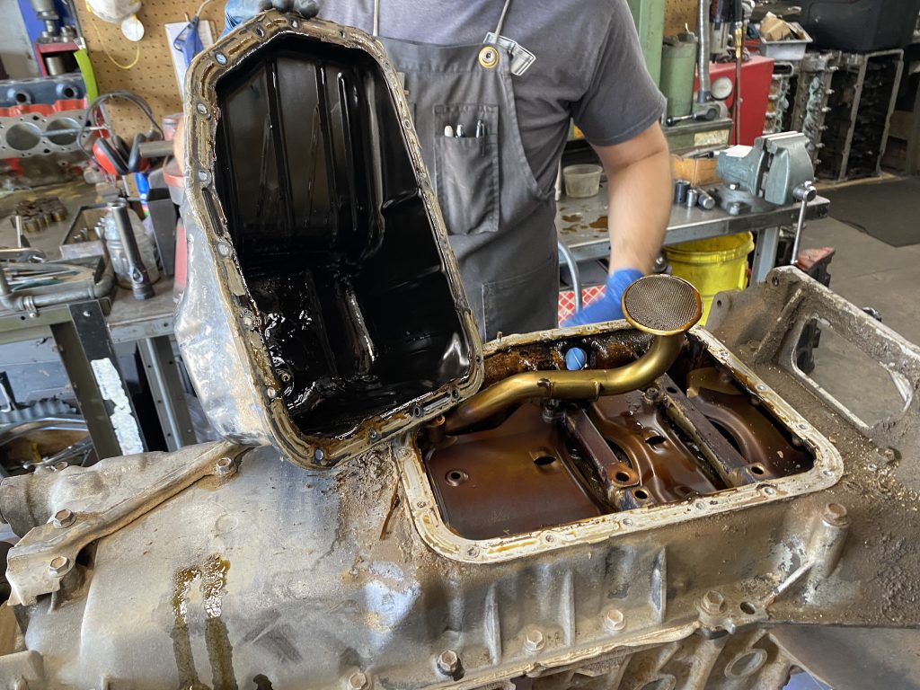 dirty oil pan removed from an engine
