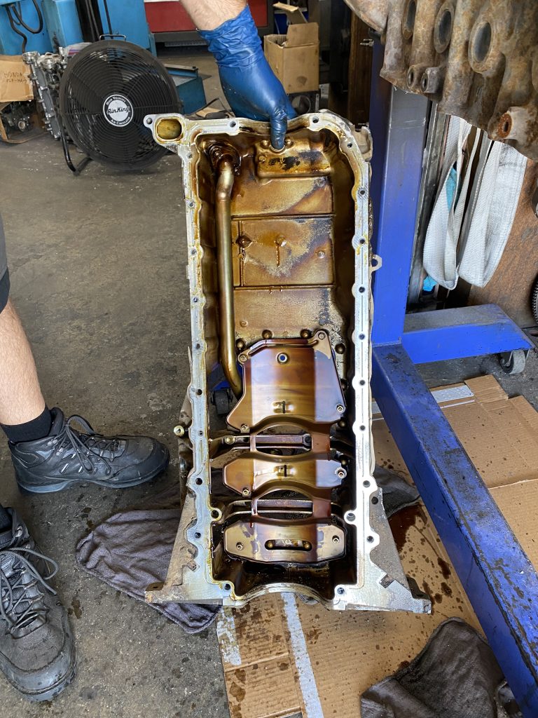 view inside a dirty used engine oil pan
