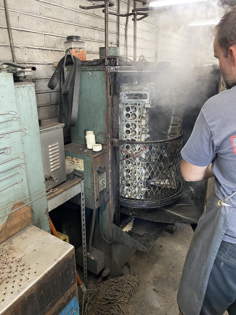 engine parts in a steam pressure wash