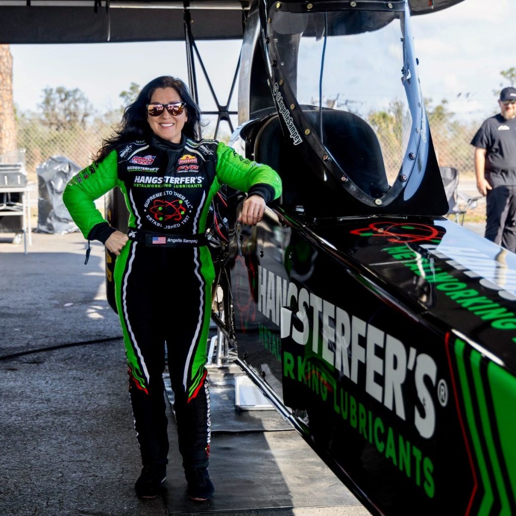 angelle sampey standing next to a top alcohol dragster