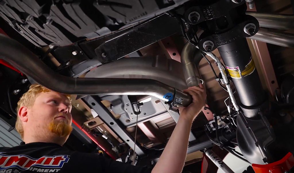 man installing a truck exhaust pipe