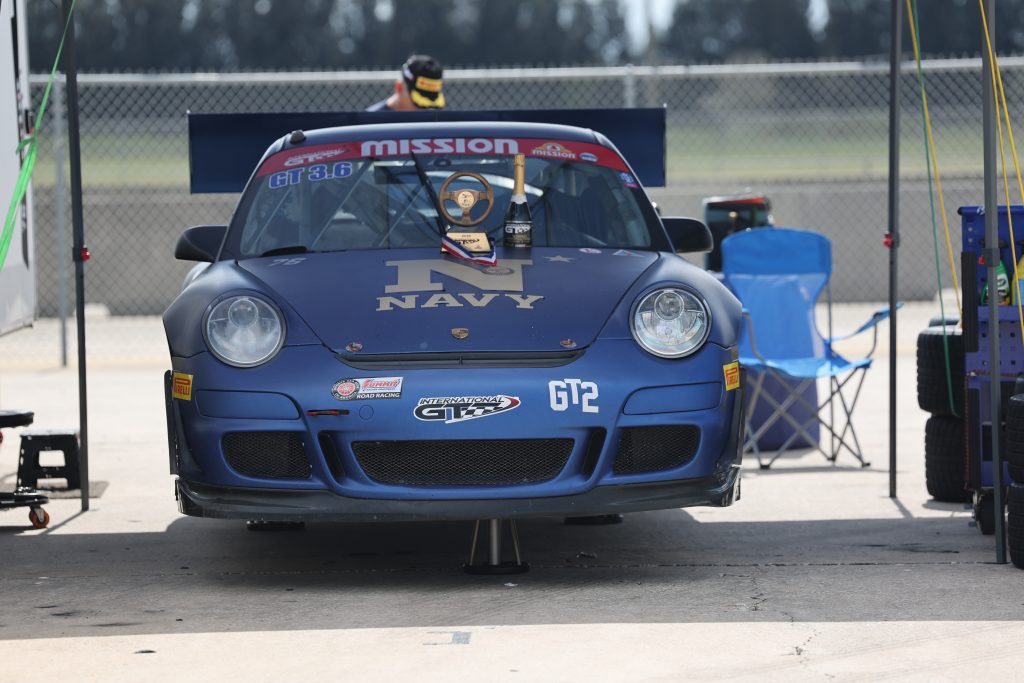blue porsche 911 race car on jackstands in pits