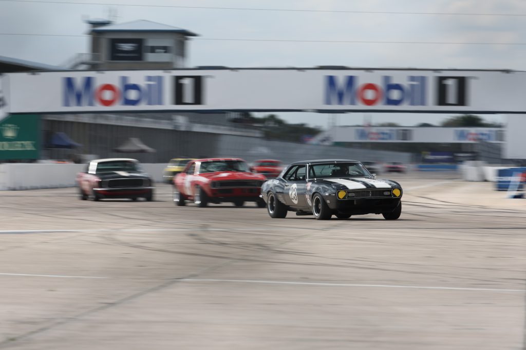 a group of vintage trans am cars exiting a corner
