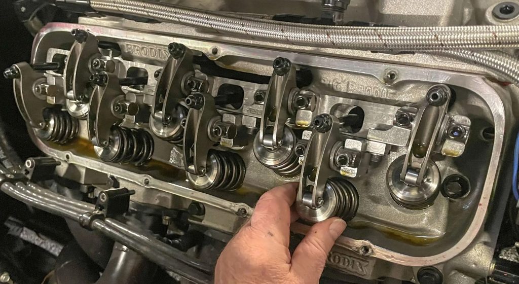 man holding valve spring inside a cylinder head cropped