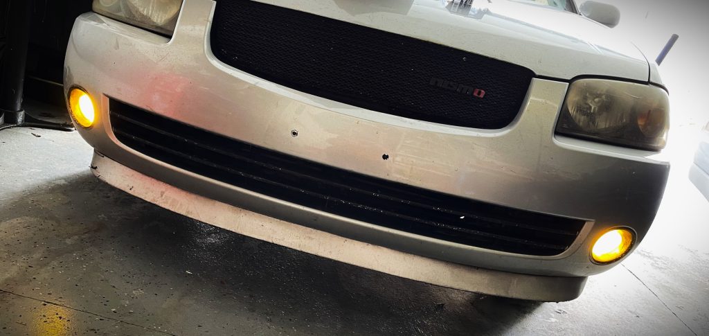 close up of front of a car with foglights on