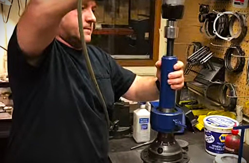 man removing a carrier bearing using a special puller tool