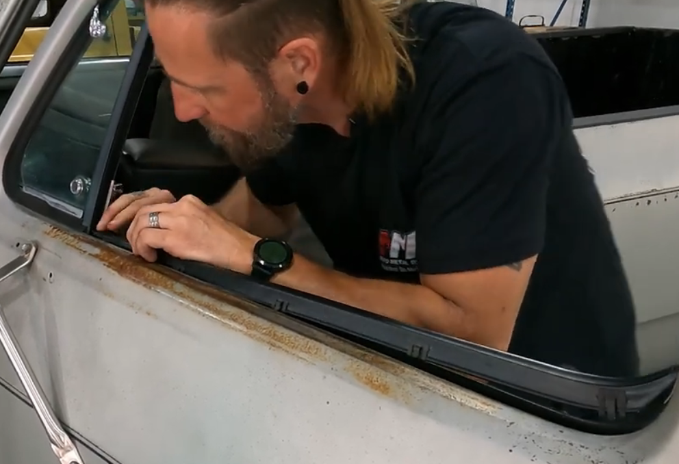 man replacing door glass window seal on an old truck