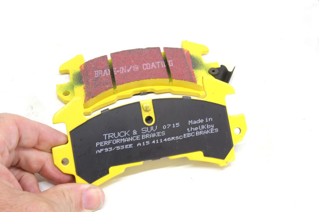 man holding brake pad in front of camera