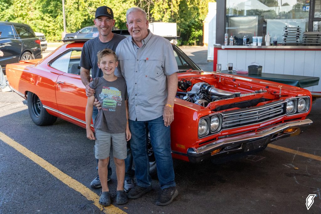 family posing next to a 1969 Plymouth Satellite