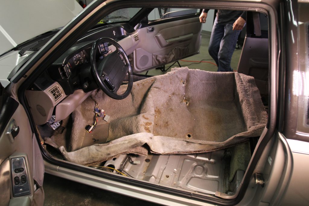 dirty old carpet getting removed from a car
